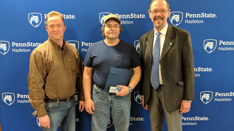 Eric Krieger, center, maintenance mechanic, was honored for 20 years of service. He is pictured with Facilities Supervisor Michael Chura, left, and Chancellor Gary Lawler.
