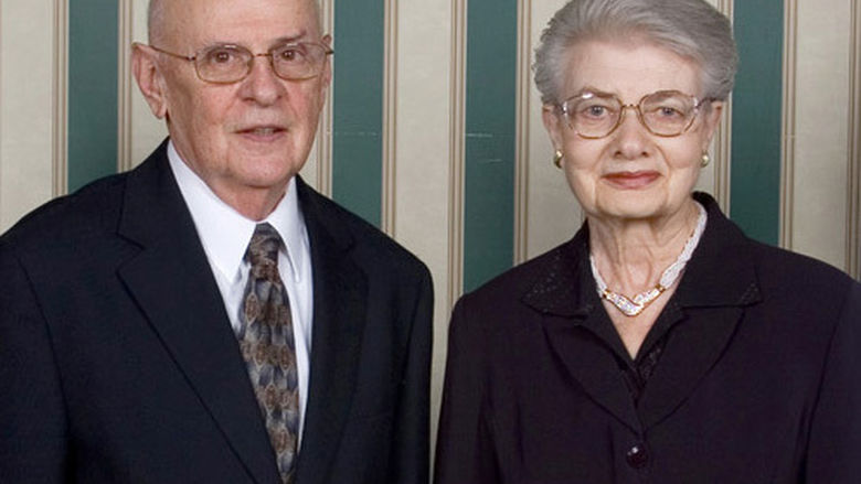 Man and Woman standing side by side in black formal wear.