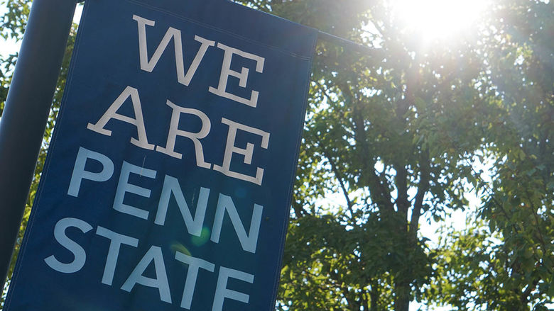 Blue 'We Are Penn State' banner with trees and sunshine in background