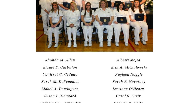 Group of nurses in white scrubs seated in two rows