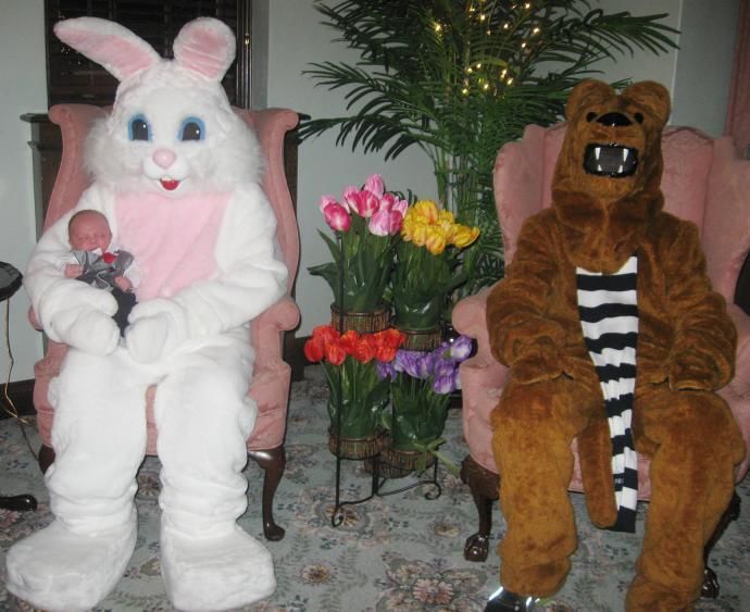 Easter bunny holding a baby and seated in a chair next to Nittany Lion