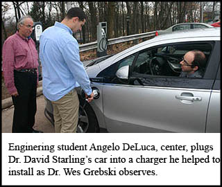 Engineering student Angelo DeLuca plugs a car into a charger. 