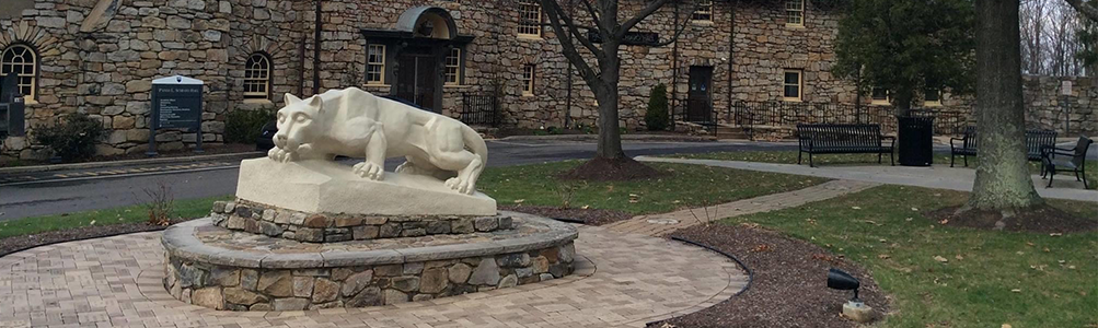 Nittany Lion statue outside brick building.