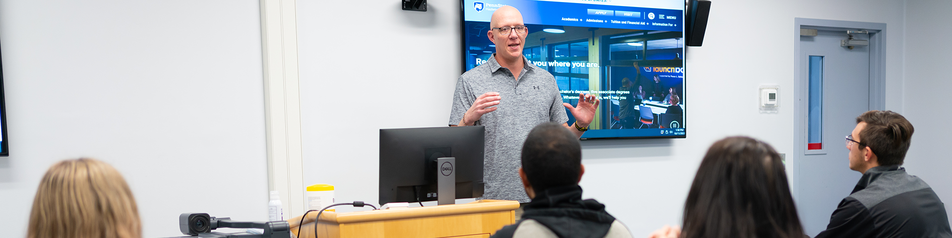 Instructor speaking in front of classroom of students.