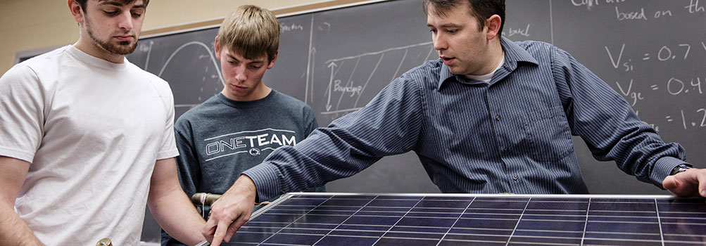 Students and instructor working on a solar panel.