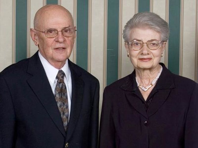 Man and Woman standing side by side in black formal wear.