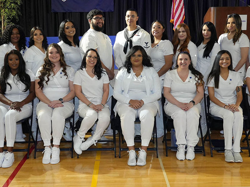 Students in scrubs seated in two rows.