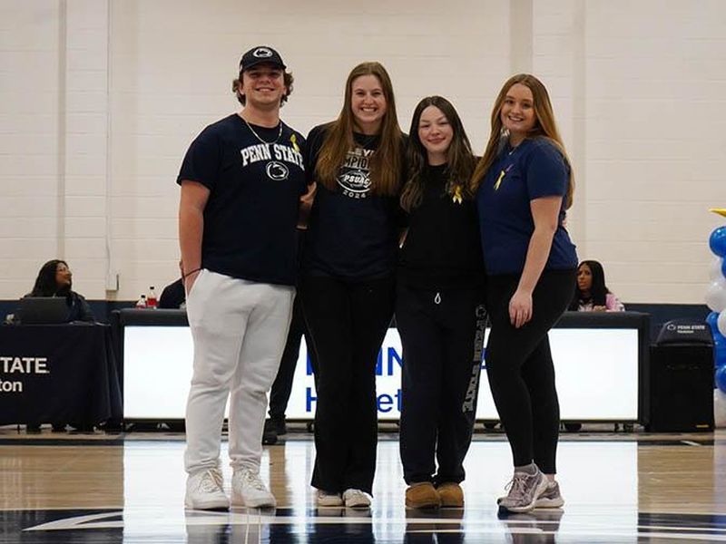 A male and three female students posing for a photo. 