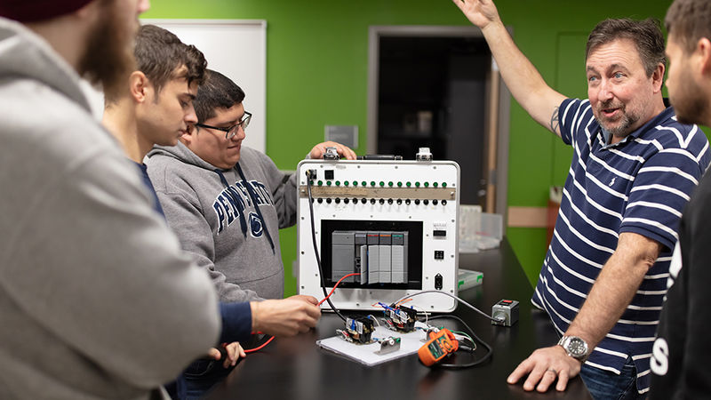 Ken Dudeck helps students use a new programmable logic controller (PLC). 
