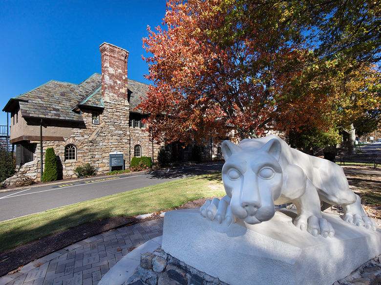 Nittany Lion statue with brick building in background.