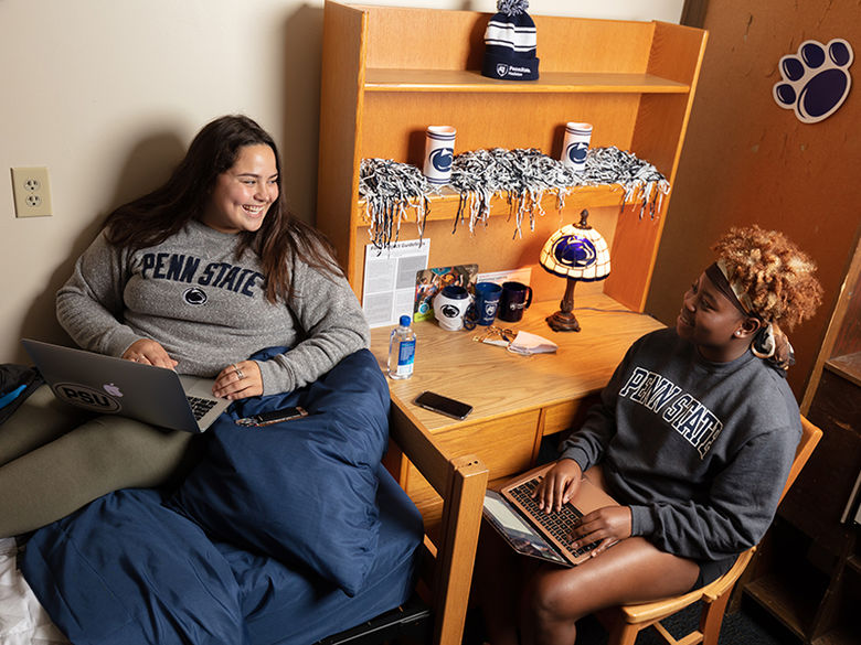 Two female students laughing in residence hall room