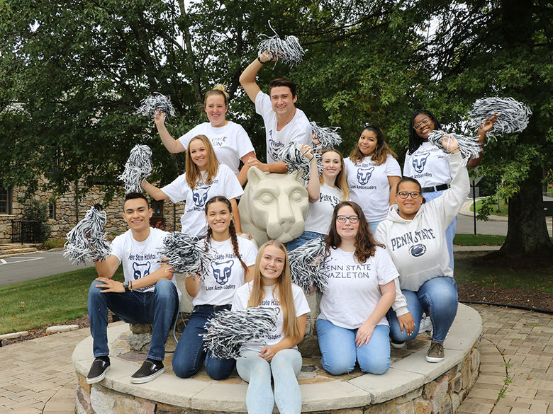 Group of students outdoors surrounding statue of Nittany Lion
