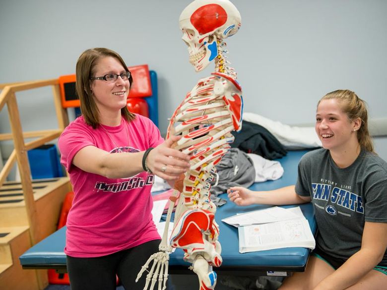 Physical Therapist Assistant students examining model skeleton.
