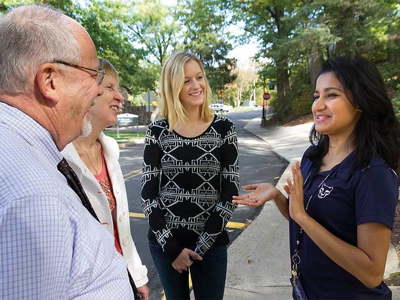 Penn State Hazleton student conducting a campus tour with a family. 