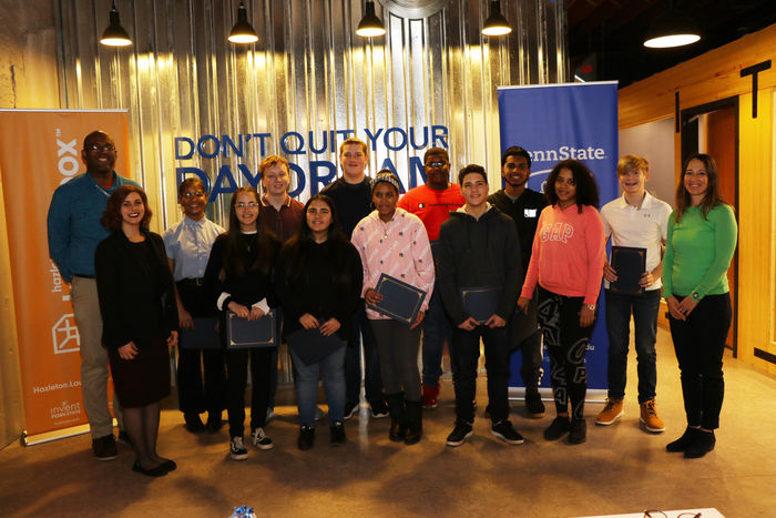 Group of students standing in rows holding certificates.