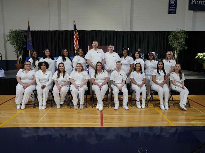 Nursing students in scrubs sitting in rows.