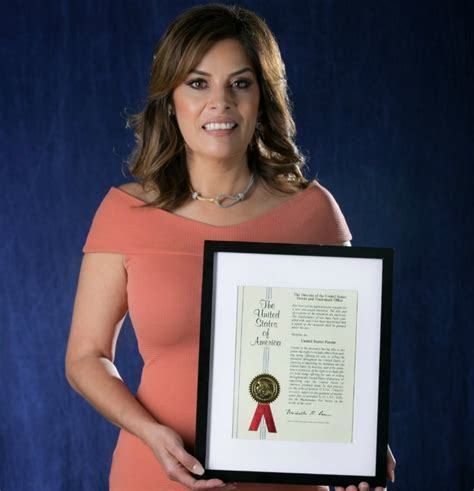 Woman in pink dress holding framed award 