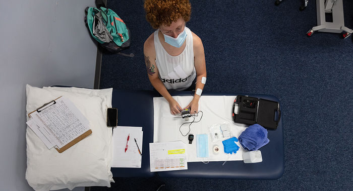 Student being photographed from above while sitting in front of desk with books and medical equipment.
