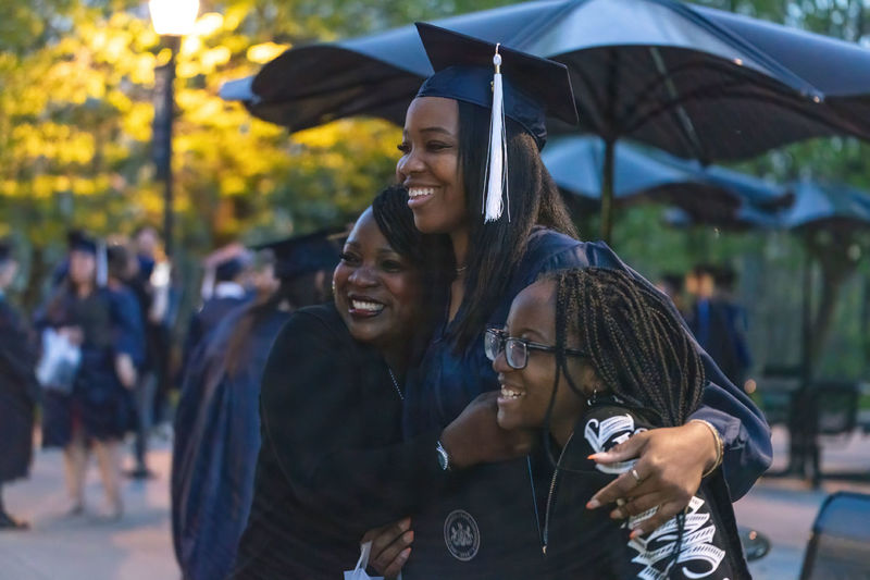 Female graduate holding loved ones during a photo.