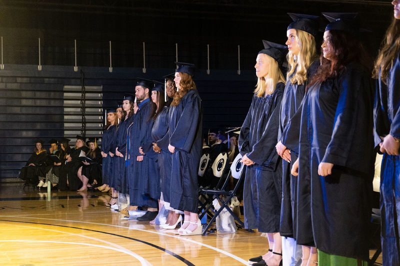 A line of students in graduation caps and gowns.
