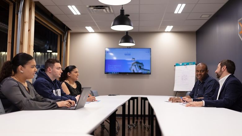 Students and instructors sitting across from each other at a table