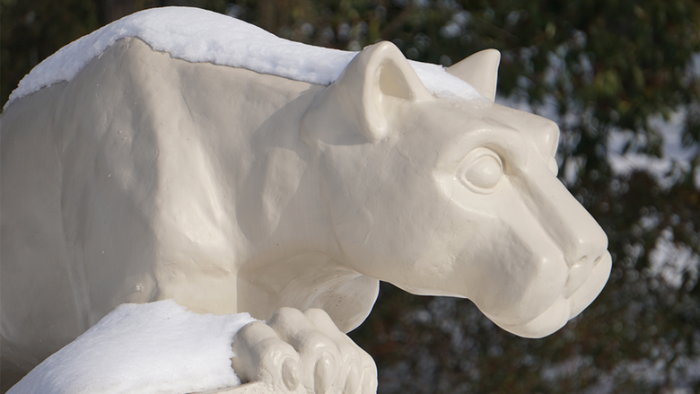 Statue of Nittany Lion coated in snow.