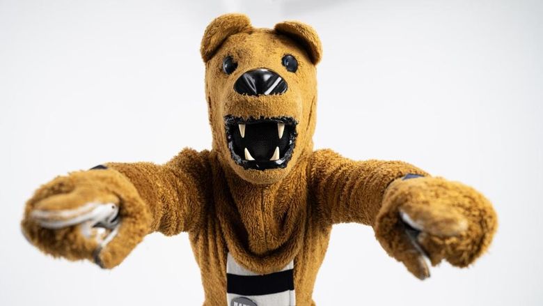 The Nittany Lion mascot points to the camera with both hands