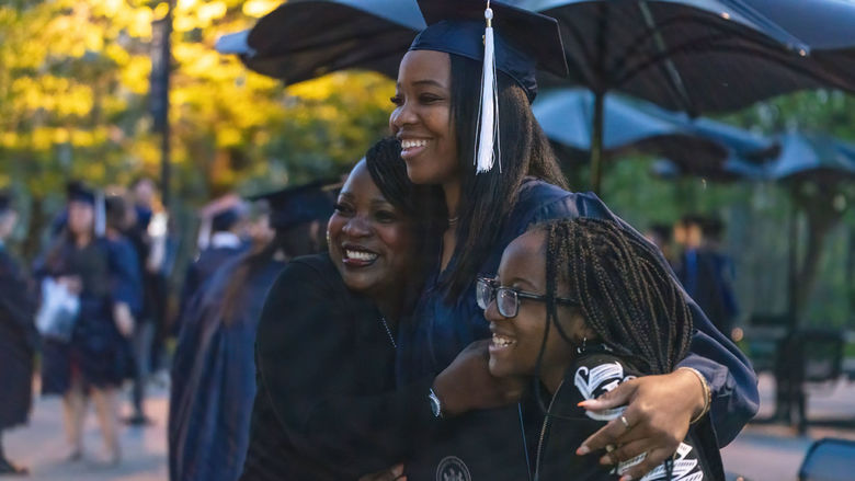 Female graduate holding loved ones during a photo.