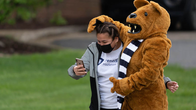 A student taking a selfie with the Nittany Lion mascot