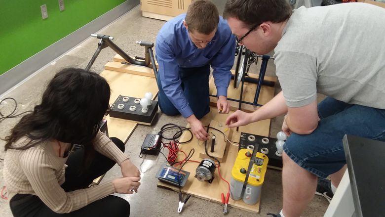 From left, Cassandra Kelly, Aleksander Everett and Steven Baksa work on a human-powered bicycle generator that they will demonstrate during PPL Energy Savings Day on Saturday. 