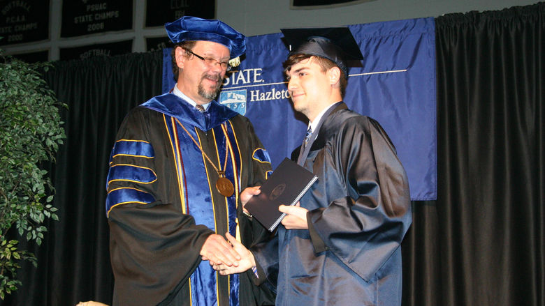 Chancellor Gary Lawler presents a diploma to Dante Toth, who earned the first Administration of Justice degree from Penn State Hazleton.