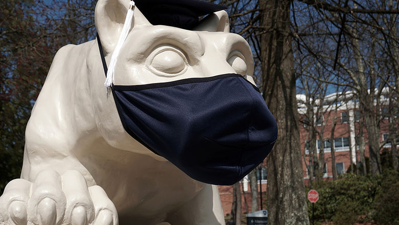 Nittany Lion Shrine decorated with mortarboard and mask.