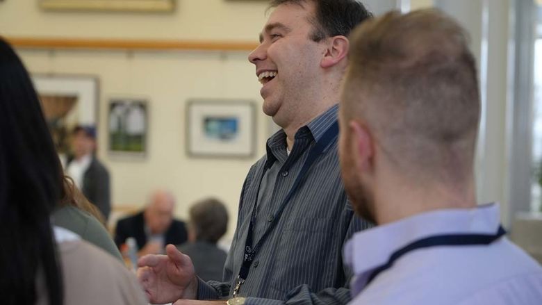 Man laughing with group of people.