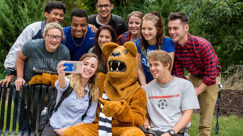 Students taking a selfie with the Nittany Lion