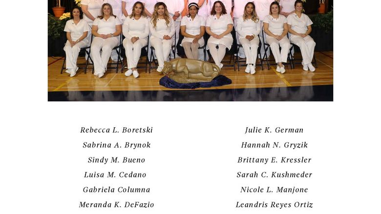 Group of nurses in white scrubs seated in two rows