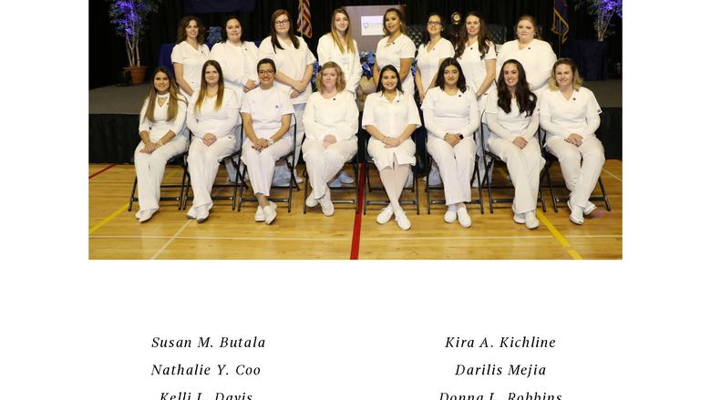 Group of nurses in white scrubs seated in two rows