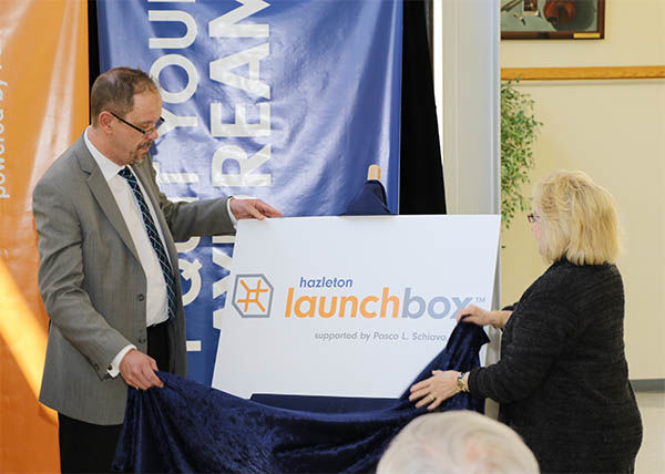 Penn State Hazleton Chancellor Gary Lawler, left, and Linda Schiavo unveil the logo for the Hazleton LaunchBox, which will be named after Linda's brother, the late Pasco L. Schiavo.