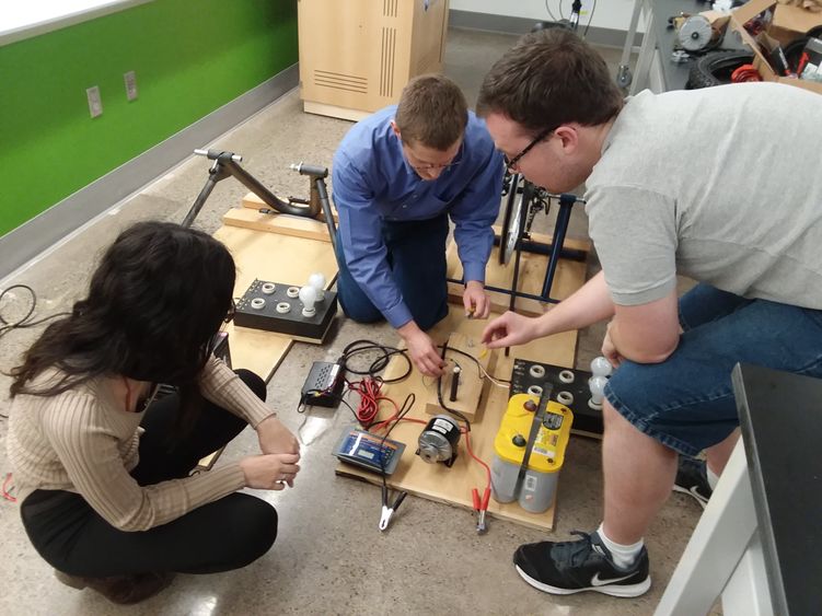 From left, Cassandra Kelly, Aleksander Everett and Steven Baksa work on a human-powered bicycle generator that they will demonstrate during PPL Energy Savings Day on Saturday. 