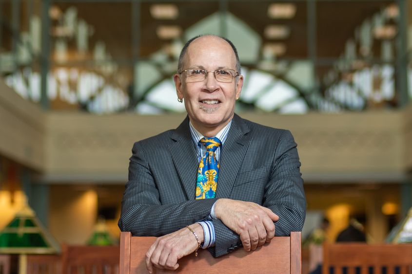 John Champagne leans on a chair in Lilley Library