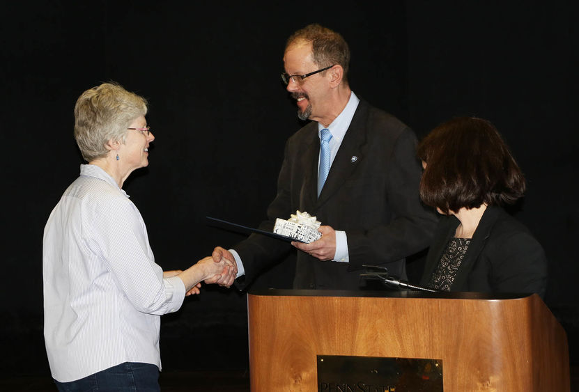Chancellor Gary Lawler shakes Patricia Ferry's hand while congratulating her on 35 years of service to Penn State Hazleton. Director of Academic Affairs Elizabeth Wright is at right.