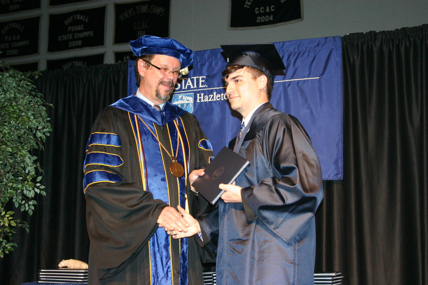 Chancellor Gary Lawler presents a diploma to Dante Toth, who earned the first Administration of Justice degree from Penn State Hazleton.