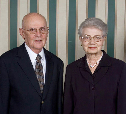 Man and Woman standing side by side in black formal wear.