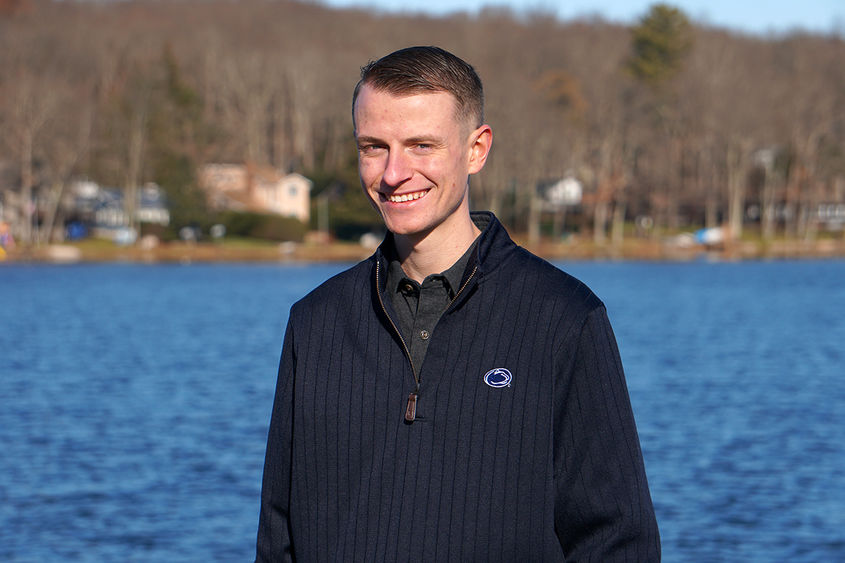 Student in Penn State sweatshirt standing in front of lake