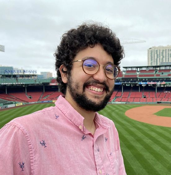 Man standing inside baseball stadium.