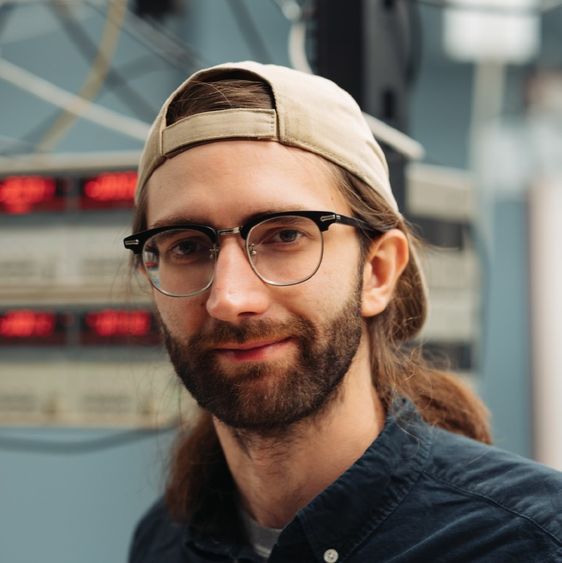 Man in glasses and a backwards baseball cap.