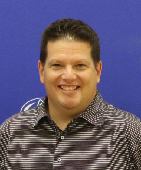 Man in striped polo shirt smiling.