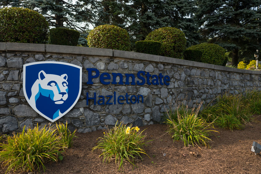 Entrance to Penn State Hazleton with stone wall featuring campus logo