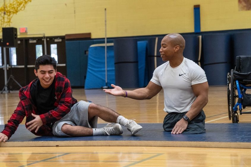 Rohan Murphy presenting at high school gym with student