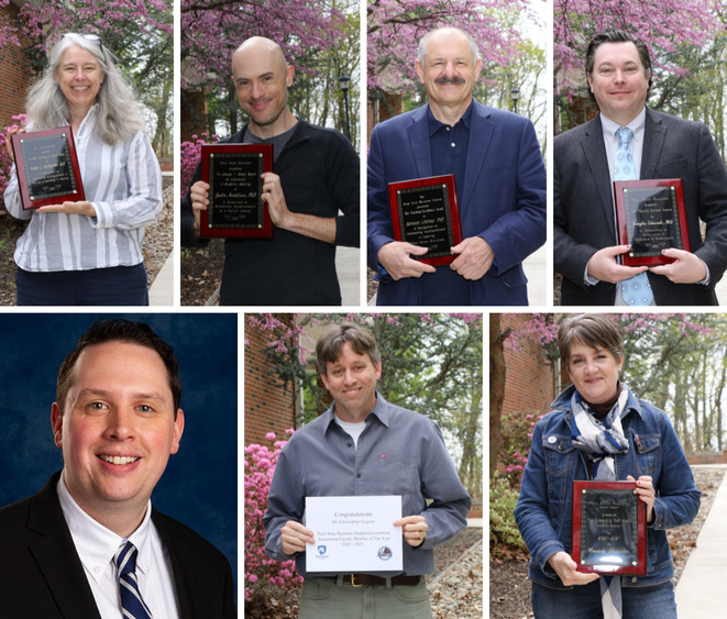 Group of Penn State Hazleton staff and faculty holding plaques outside on campus mall.